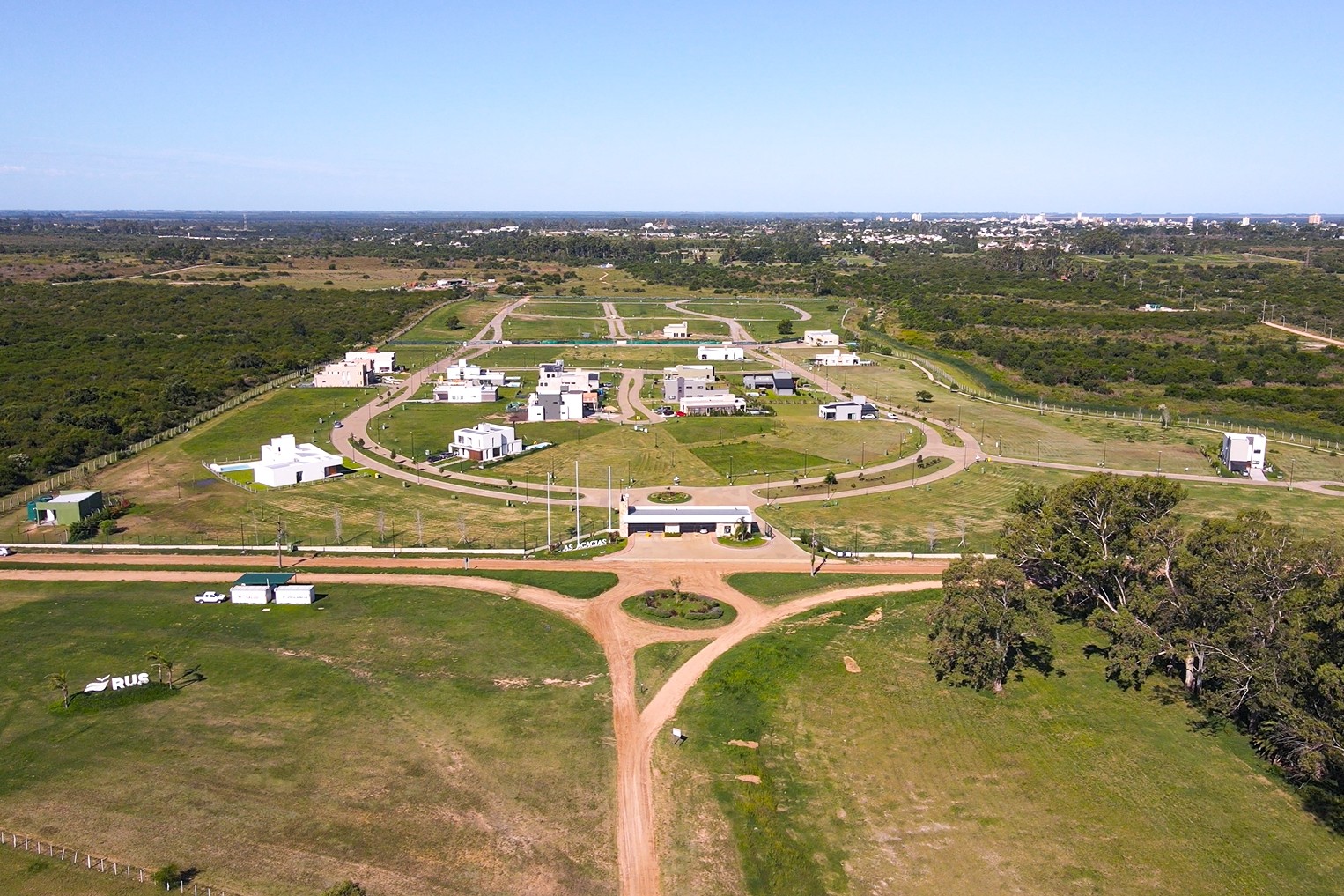 Vista aérea de un loteo con calles, espacios verdes y viviendas